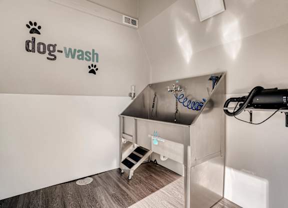 A dog wash station with a sign on the wall at The Ranch at Bear Creek Apartments, Colorado