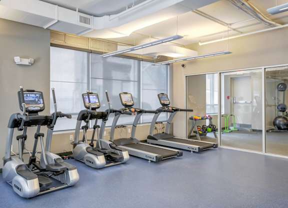 A gym with treadmills and elliptical machines.at 222 Saratoga, Baltimore Maryland