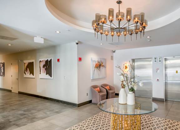 A modern interior with a glass table and a chandelier.