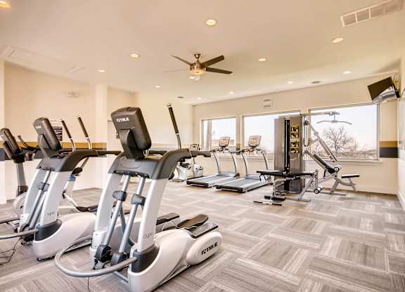 A gym with treadmills and elliptical machines at Mountain Vista Apartments, Lakewood, Colorado