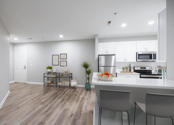an open kitchen and living room with a large island and stainless steel appliances at The Lena, Raritan, NJ 08869