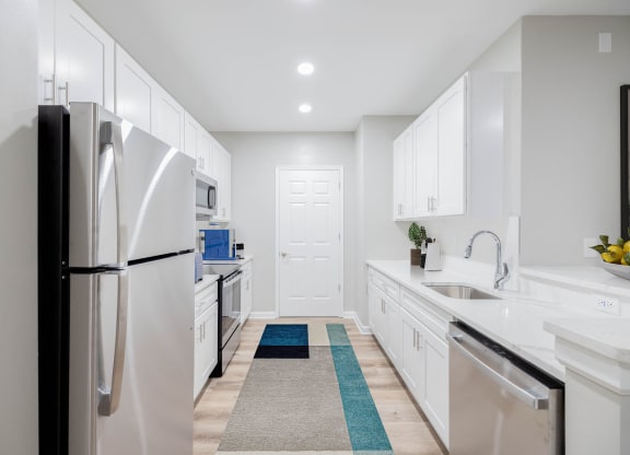 a white kitchen with white cabinets and stainless steel appliances at The Lena, Raritan, NJ 08869