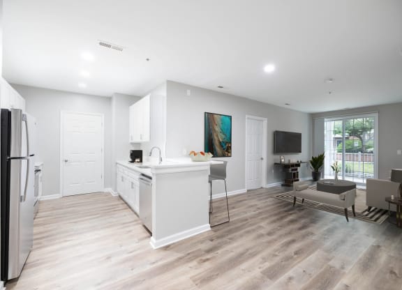 an open kitchen and living room with white walls and wood floors at The Lena, Raritan, NJ 08869