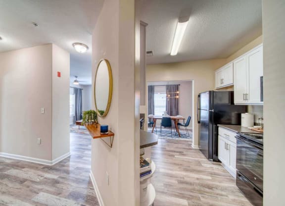 a kitchen and living room with a black refrigerator freezer and a black stove top oven at Meridian Obici, Virginia, 23434