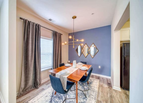 a dining room with a table and chairs and a chandelier at Meridian Obici, Suffolk