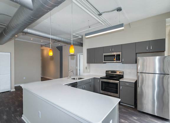 A modern kitchen with stainless steel appliances and a white island.