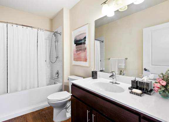 A white toilet sits next to a white bathtub in a bathroom  at Metro 303, Hempstead, NY, 11550