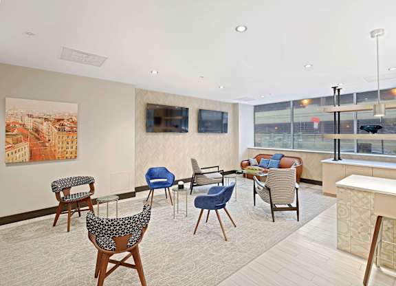 A living room with a large painting of a cityscape on the wall and a row of chairs in front of it.
