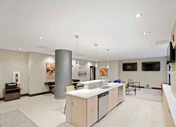 A modern kitchen with a large island and pendant lights.