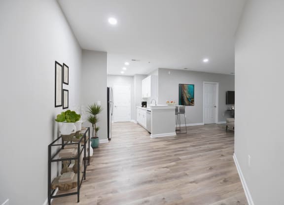 a living room and kitchen with white walls and a wooden floor at The Lena, Raritan, NJ 08869