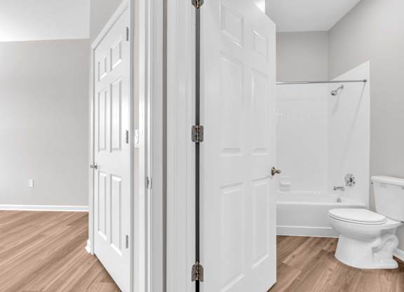 A white bathroom with a toilet and a shower.