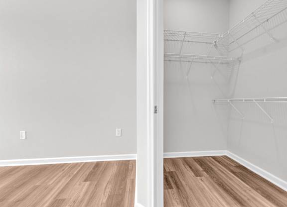 A room with a white door and a wooden floor.