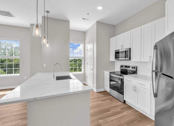 A modern kitchen with a large island and stainless steel appliances.
