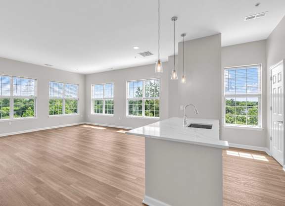 A kitchen with a large island and pendant lights.