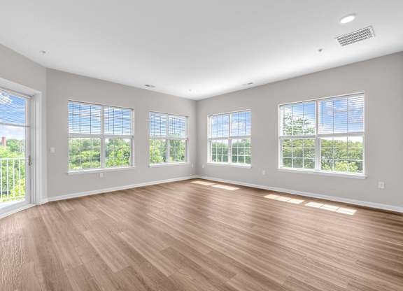 A room with wooden floors and large windows.
