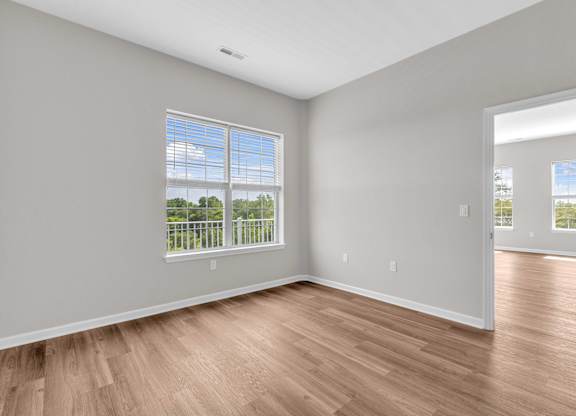 A room with wooden floors and a large window.