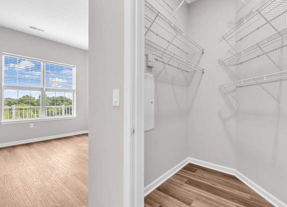 A room with a window and a wall of shelves.