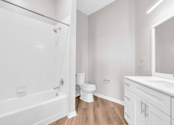 A white bathroom with a tub, toilet, and sink.