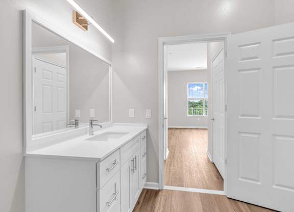 A white bathroom with a sink and mirror.