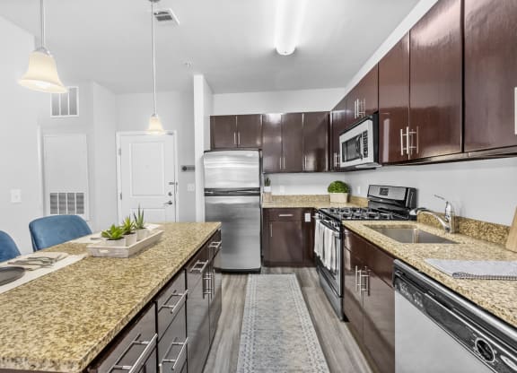 a kitchen with wooden cabinets and granite countertops at Harbor Pointe in Bayonne, NJ
