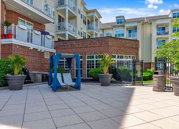 A playground area with a slide and potted plants in front of apartment buildings.