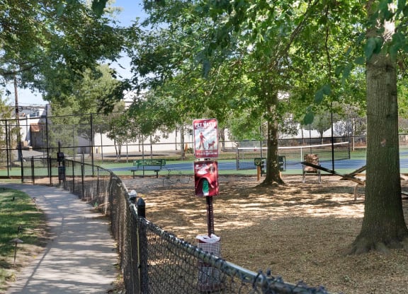 a private dog park with a tennis court in the background and trees in the foreground  at The Lena, Raritan, NJ, 08869