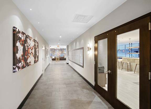 A hallway with a brown door and a painting on the wall.