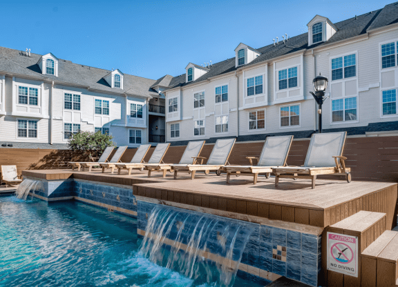 a pool with a waterfall and a row of lounge chairs at Harbor Pointe  at Harbor Pointe, Bayonne, NJ, 07002