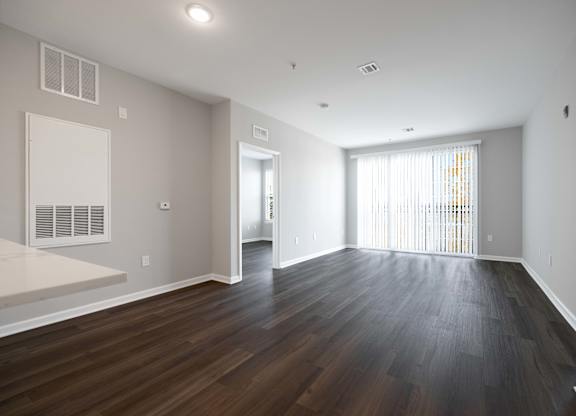A large empty room with wooden floors and white walls.