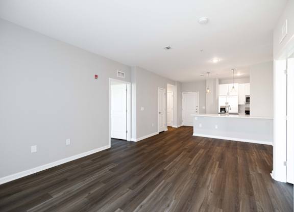A room with wooden flooring and white walls.