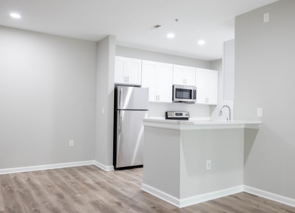 a kitchen with white cabinets and a stainless steel refrigerator at The Lena, Raritan, NJ 08869