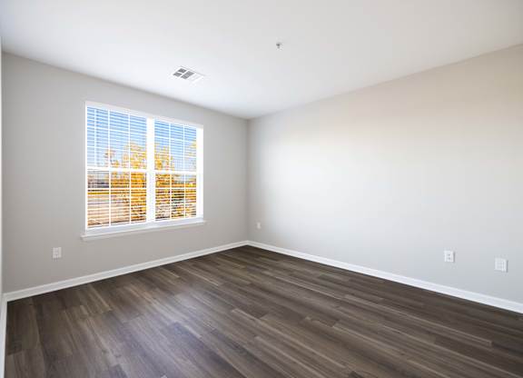 A room with a window showing trees outside.