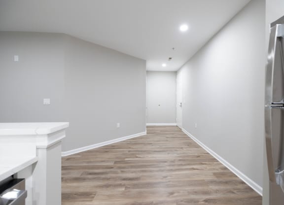 a renovated kitchen with white walls and wood flooring and a stainless steel refrigerator at The Lena, Raritan, NJ 08869