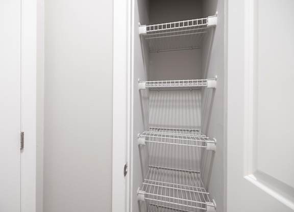 Empty white shelves in a white pantry.