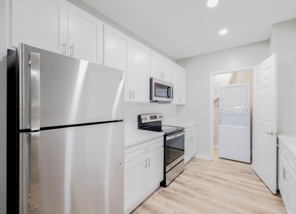 a white kitchen with stainless steel appliances and white cabinets at The Lena, Raritan, NJ 08869