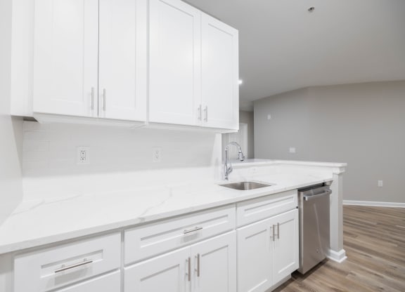 a white kitchen with white cabinets and a stainless steel sink at The Lena, Raritan, NJ 08869