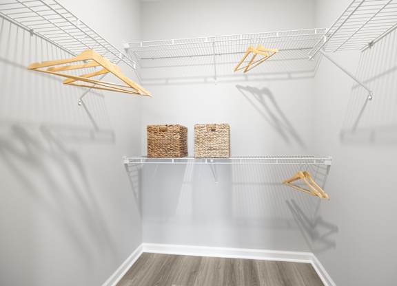 A white pantry with two shelves and hangers at Harbor Pointe Apartments, New Jersey