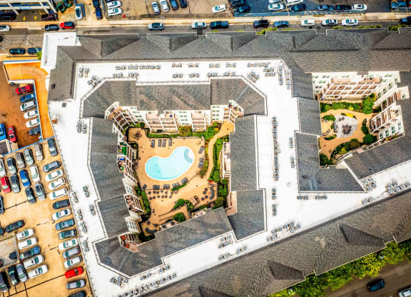 an aerial view of a building with a pool and parking lot at Metro 303, Hempstead, NY