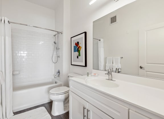 a bathroom with a bathtub toilet and sink at Metro 303, Hempstead, NY 11550
