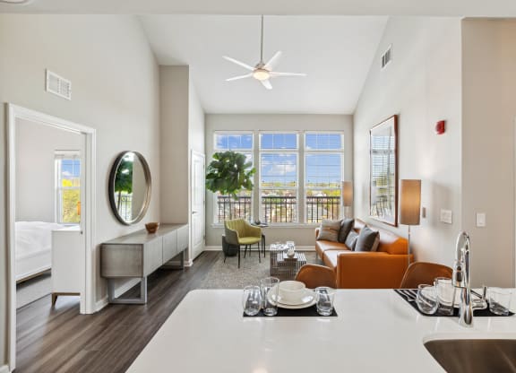 a living room with white walls and a large window with a view of a body of water at Metro 303, Hempstead