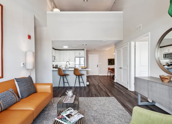 a living area with a couch coffee table and a kitchen in the background at Metro 303, Hempstead, 11550