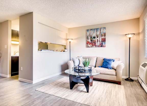 A living room with a white couch and a coffee table at Mountain Vista Apartments, Lakewood, CO
