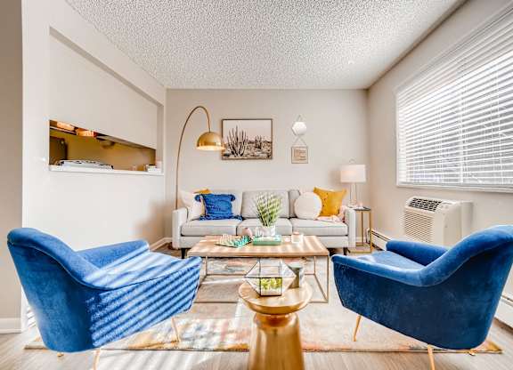 A living room with a blue chair and a white couch at Mountain Vista Apartments, Colorado, 80228