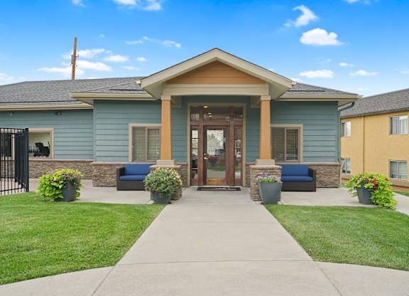 A building with a blue and yellow exterior and a brown door at Mountain Vista Apartments, Lakewood, CO