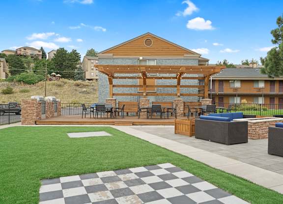 A large wooden building with a checkered pattern on the ground in front of it at Mountain Vista Apartments, Lakewood, Colorado