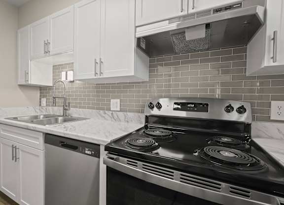 A kitchen with a stove, sink, and cabinets at The Ranch at Bear Creek Apartments, Lakewood, 80227