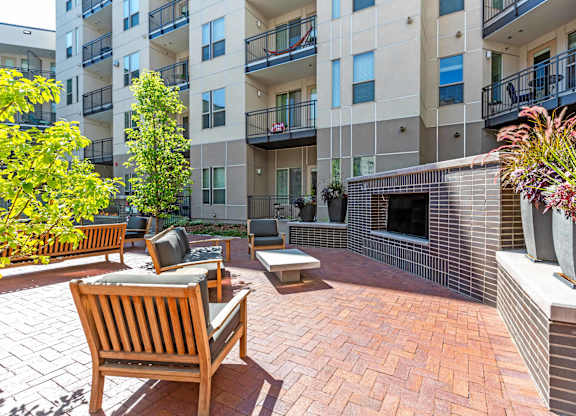 A patio with a bench and a fireplace in front of a building at Regatta Sloans Lake Apartments, Denver, 80204