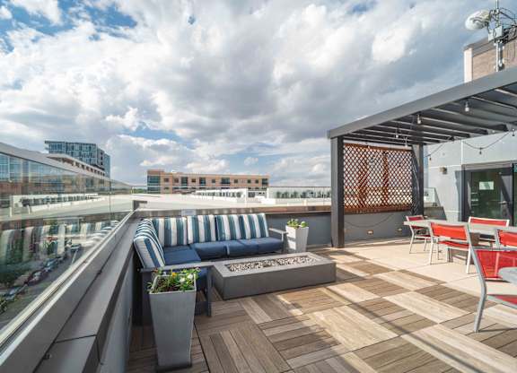 A rooftop patio with a blue couch and wooden deck at Regatta Sloans Lake Apartments, Colorado, 80204