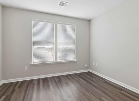 a bedroom with hardwood floors and a large window at Metro 303, Hempstead