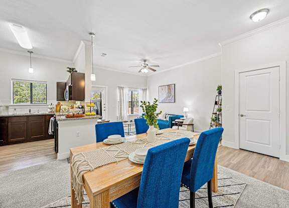 Dinning table with blue chairs at The Laurel at Vintage Park 55+ Apartments, Tomball, TX, 77377